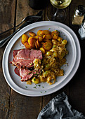 Gammon with wine sauerkraut, fried potatoes and a glass of white wine