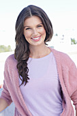 A young woman with long hair wearing a purple t-shirt and a wrap-around jumper