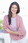 A young woman with long hair wearing a purple t-shirt and a wrap-around jumper