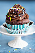 A vegan chocolate cupcake with sugar sprinkles