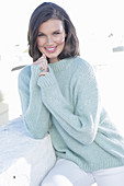 A young woman wearing a light knitted jumper