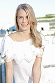 A young blonde woman wearing a Carmen blouse with crochet detail