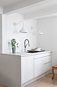 Two wall lamps above white kitchen counter in country-house style