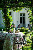 Romantically set tea table in summery château garden
