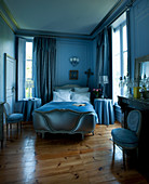 Blaues Schlafzimmer mit Antikmöbeln und Kamin