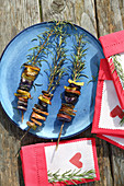 Colourful potatoes grilled on sprigs of rosemary and decorated napkins