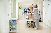 Nurse pushing hospital bed in corridor
