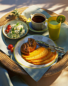 Frühstücksteller mit Käse, Brötchen, Salat, Kaffee und Fruchtsaft