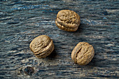 Three walnuts on a wooden surface