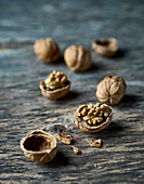 Whole and shelled walnuts on a wooden surface