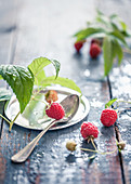 Himbeeren mit Himbeerblättern auf Holztisch