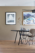 Dining table with designer chairs and photographic art on taupe wall