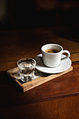 Cup with an espresso coffee in a wooden table