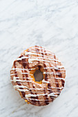 Traditional sweet doughnut with icing on light marble surface