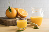 Orangensaft im Glas und in einer Glaskaraffe