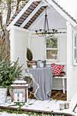 Gemütlich dekorierte Gartenlaube mit Terrasse im winterlichen Garten