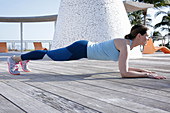 A brunette woman performing a plank