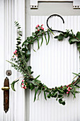 Wintry wreath of eucalyptus and snowberries on door