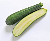 Zucchini, whole and halved on a white background