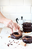 Vegane Mandel-Schokoladen-Donuts mit Schokoladencreme bestreichen