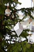 Origami, Kerze und Holzkugel am Weihnachtsbaum