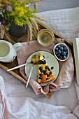 Ein Stück Blaubeer-Käsekuchen auf Frühstückstablett im Bett