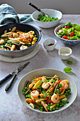 Colorful pasta with shrimps and green peas in a white wine sauce