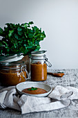 Homemade tasty spicy chutney mango in glass jars and bowl on table