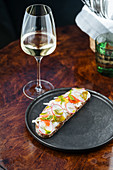 Colorful sandwiches with red radish sliced and herbs in white sauce with wine