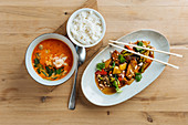 Vegetables in plate with chopsticks with spicy seafood soup and with of boiled rice