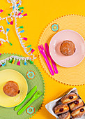 Donuts with jam, served on colorful plates, during kids party