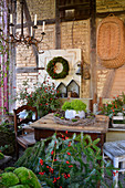 Moss wreath, conifer branches and rose hips in autumnal seating area in barn