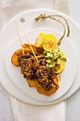 Spicy veal heart kebabs on sweet potatoes, sweetcorn and avocado