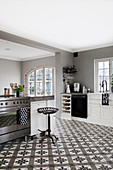 Großzügige Landhausküche in Schwarz, Weiß und Grau mit dekorativem Ornamentfliesenboden