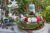 Homemade moss wreath cake with a candle in the middle, cake stand with cones and stars