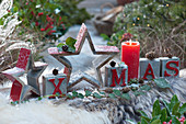 Moderne Weihnachtsdekoration mit Sternen, Kerze und Botschaft XMAS