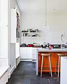 Große offene Küche mit Kücheninsel und Farbakzent in Orange