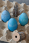 Blue Easter eggs decorated with lettering reading 'BLUE' in 3 languages