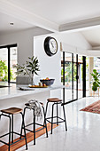 Marble breakfast bar with bar stools in white, open-plan interior