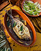Fried gilt-head bream with onions and bay leaves