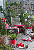 Weihnachtliche Terrasse mit Kiefer und Zuckerhutfichte, geschmückt mit Sternen und Lichterkette