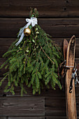 Weihnachtsdekoration aus Fichtenzweigen an rustikaler Holzwand