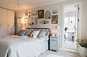 Spiegelsammlung überm Bett im nostalgischen Schlafzimmer in Weiß