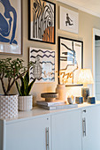 Gallery of graphic artworks above sideboard