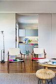 50s chairs with colourful upholstery in front of sliding door leading into kitchen