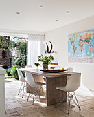 Shell chairs at table in modern dining room with access to garden