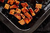 Oven-baked tempeh pieces drizzled with soy sauce