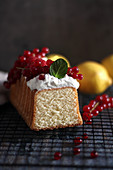 A loaf cake served with cream and summer berries, sliced