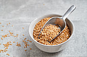 Golden flax seeds in a bowl and a scoop