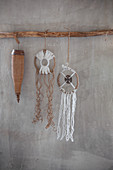 Rustic dreamcatchers hung from branch on grey wall